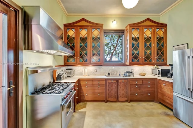 kitchen featuring crown molding, a sink, appliances with stainless steel finishes, and wall chimney range hood