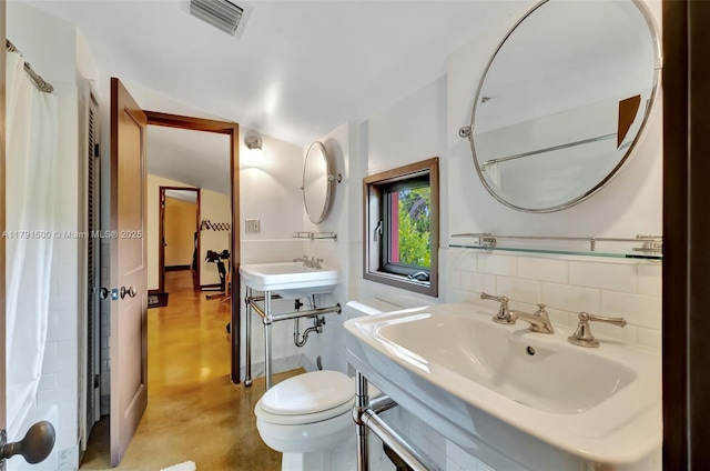 full bathroom featuring concrete flooring, a sink, toilet, a shower with shower curtain, and visible vents