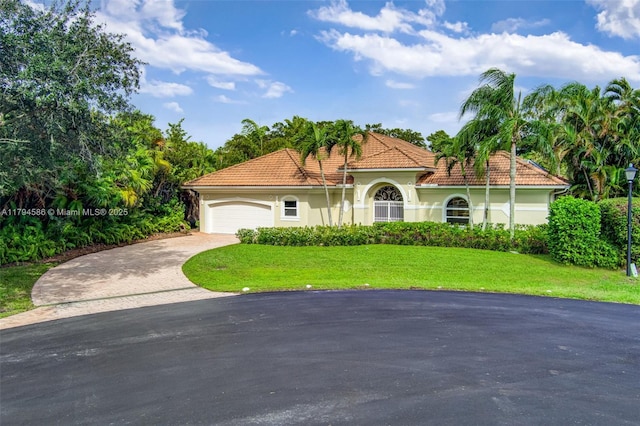 4 Mccairn Ct, Palm Beach Gardens, FL 33418 - mediterranean / spanish-style house with aphalt driveway, a front yard, stucco siding, a tiled roof, and an attached garage