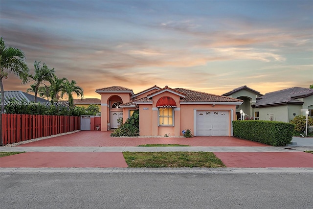 13230 NW 10th St, Miami, FL 33182 - mediterranean / spanish home with fence, an attached garage, a tile roof, stucco siding, and decorative driveway