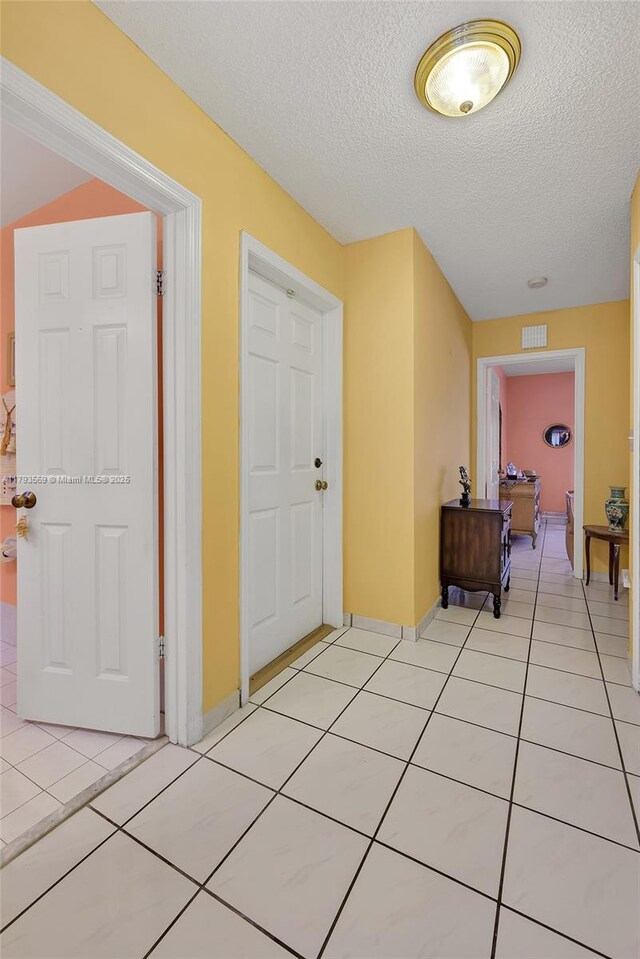 13230 NW 10th St, Miami, FL 33182 - hall featuring baseboards, light tile patterned flooring, a textured ceiling, and visible vents