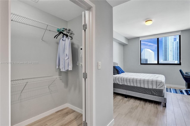 bedroom with baseboards and wood finished floors