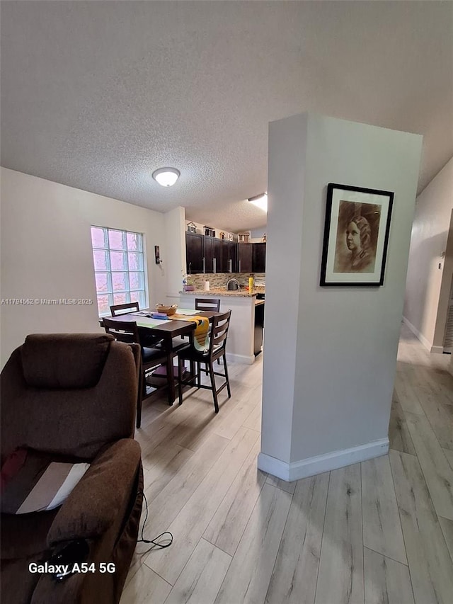 20401 SW 1st St, Pembroke Pines, FL 33029 - dining room featuring a textured ceiling, baseboards, and light wood-style floors