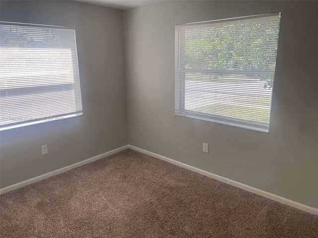 empty room with carpet floors and baseboards