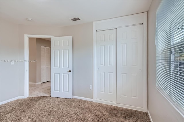 6437 Custer St, Hollywood, FL 33024 - unfurnished bedroom with visible vents, a closet, light tile patterned flooring, baseboards, and light colored carpet