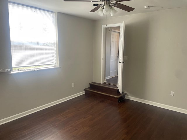 empty room featuring baseboards, ceiling fan, and wood finished floors