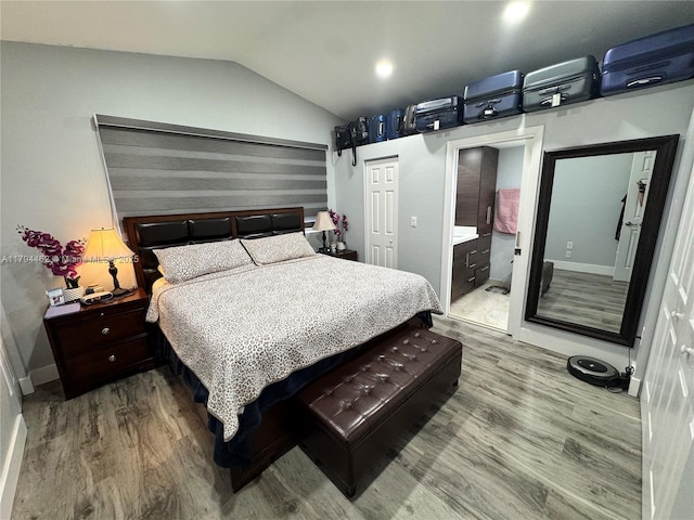 bedroom with baseboards, a closet, wood finished floors, and lofted ceiling