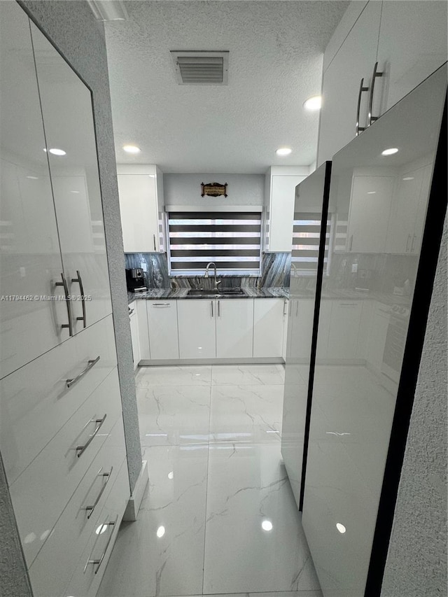 bathroom featuring vanity, visible vents, a textured ceiling, and marble finish floor