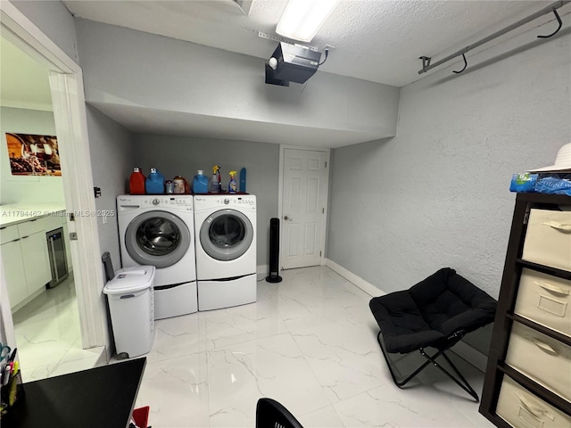 clothes washing area featuring laundry area, a textured ceiling, independent washer and dryer, beverage cooler, and marble finish floor