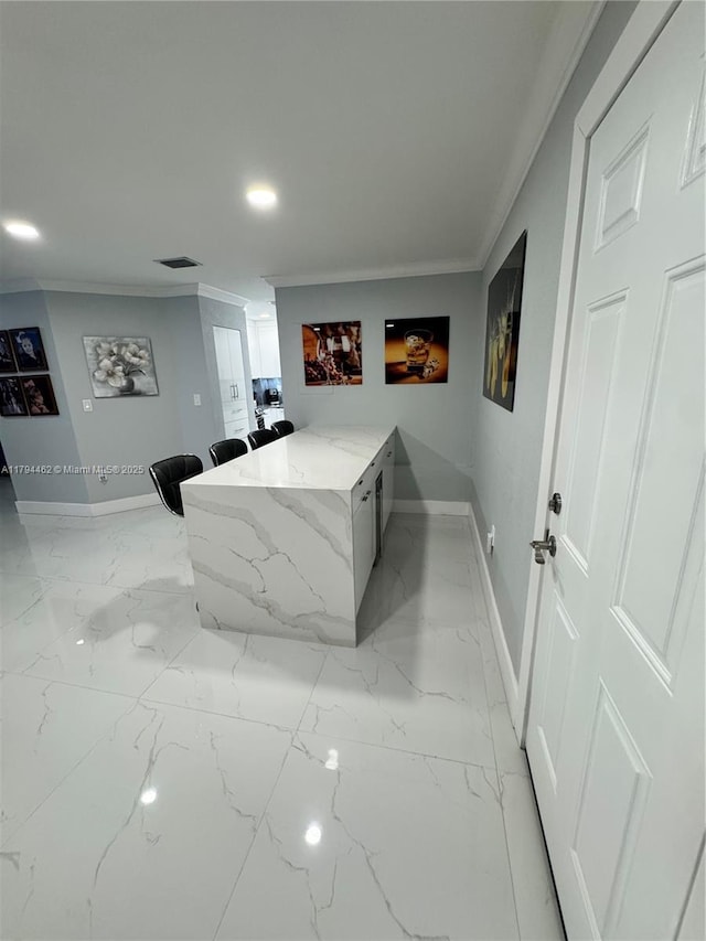 interior space featuring visible vents, ornamental molding, baseboards, and marble finish floor