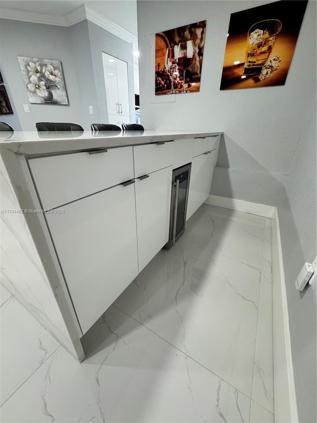 bathroom featuring crown molding, vanity, baseboards, and marble finish floor