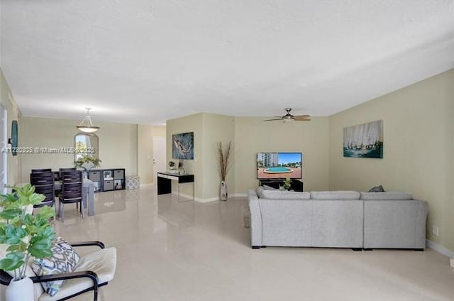 living room featuring baseboards, a ceiling fan, and tile patterned floors