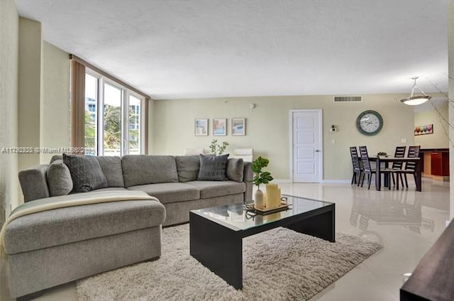 living area featuring tile patterned floors and visible vents