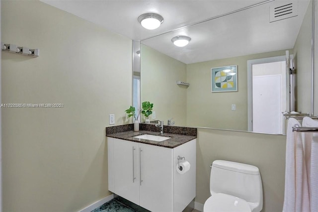 half bath featuring toilet, baseboards, visible vents, and vanity