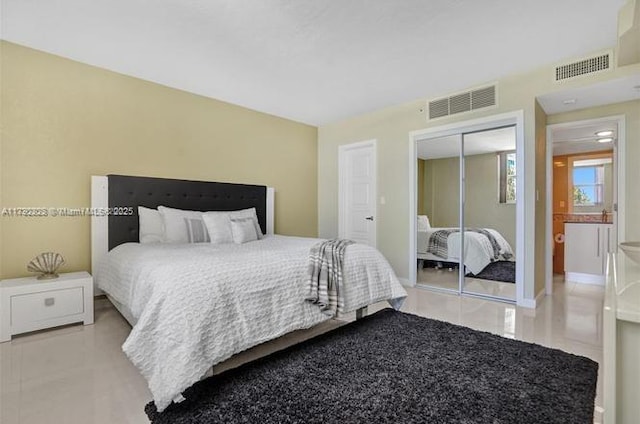 tiled bedroom featuring visible vents and a closet
