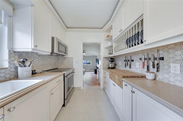 kitchen featuring light countertops, stainless steel appliances, open shelves, and tasteful backsplash