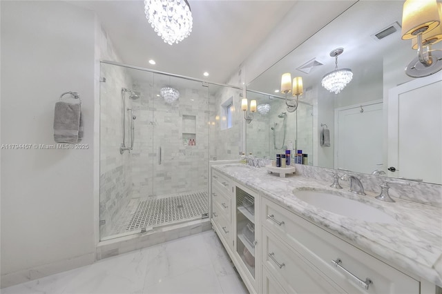 bathroom with visible vents, a stall shower, a notable chandelier, a sink, and marble finish floor