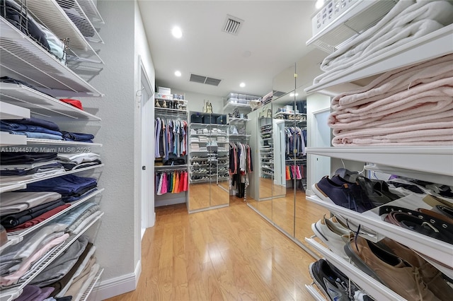 walk in closet with visible vents and wood finished floors