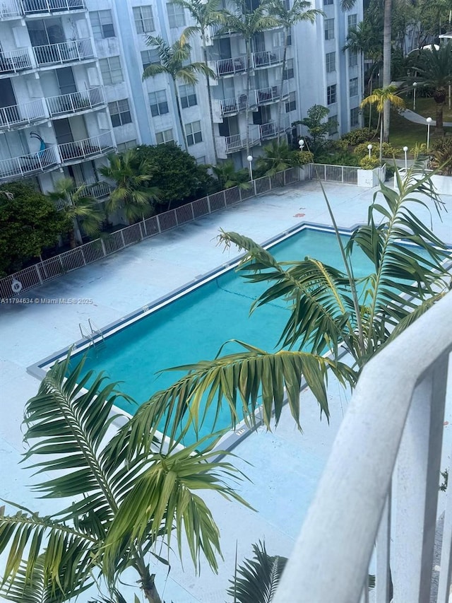 community pool with fence and a patio area