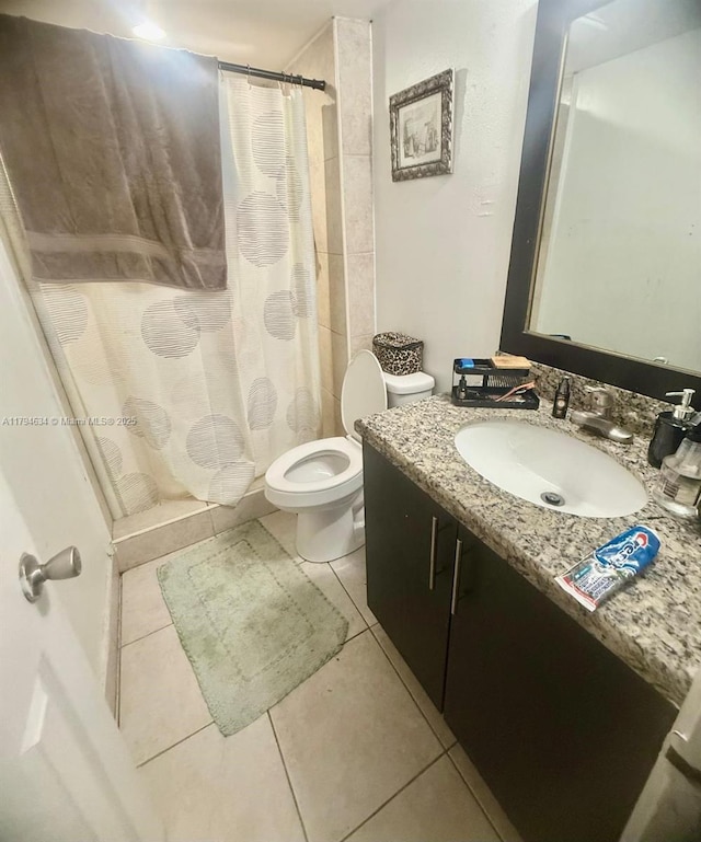 bathroom with toilet, tile patterned floors, a shower stall, and vanity