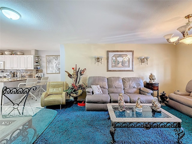 carpeted living room featuring a sink and a textured ceiling