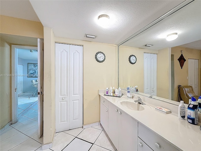 bathroom featuring a textured ceiling, visible vents, tile patterned floors, and vanity