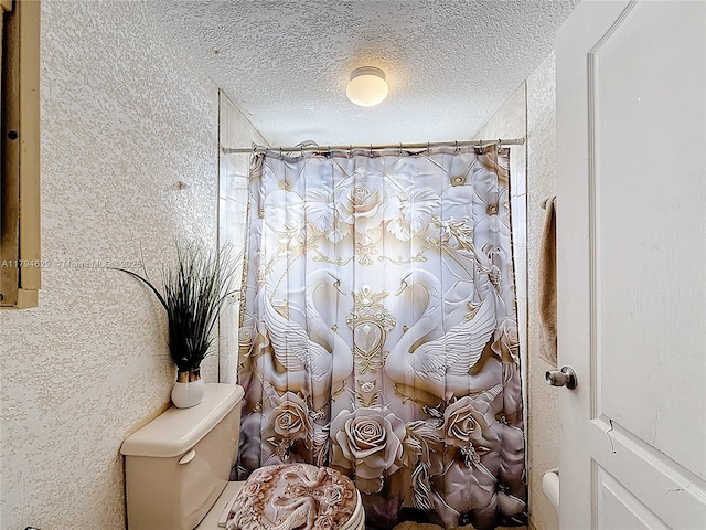 bathroom featuring a textured ceiling, a shower with shower curtain, and toilet