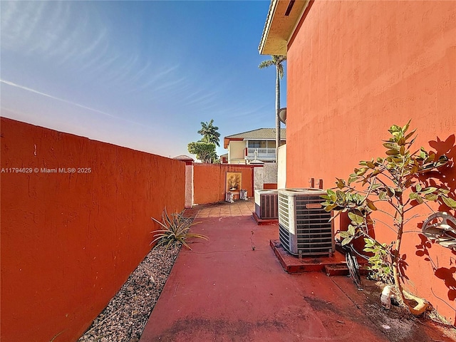 view of patio with central AC and fence