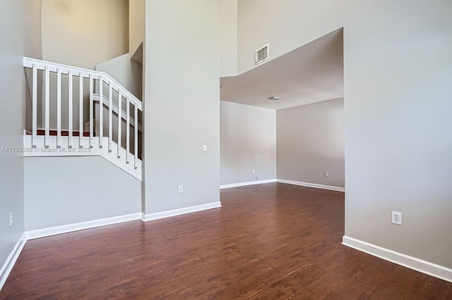 unfurnished living room with baseboards, visible vents, and wood finished floors