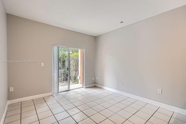 spare room featuring light tile patterned floors and baseboards