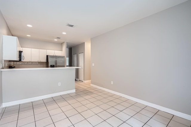 kitchen with visible vents, light countertops, white cabinets, a peninsula, and stainless steel appliances