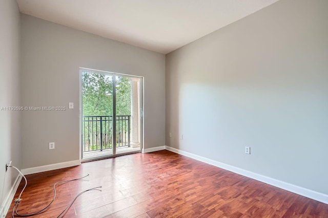 unfurnished room with baseboards and wood finished floors