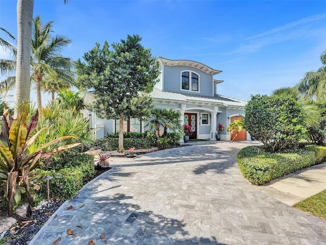 view of front of home with driveway, metal roof, and stucco siding