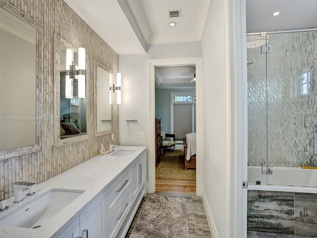 ensuite bathroom with wood finished floors, visible vents, a sink, and ensuite bath