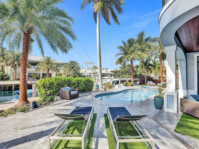 view of pool with a patio and a pool with connected hot tub