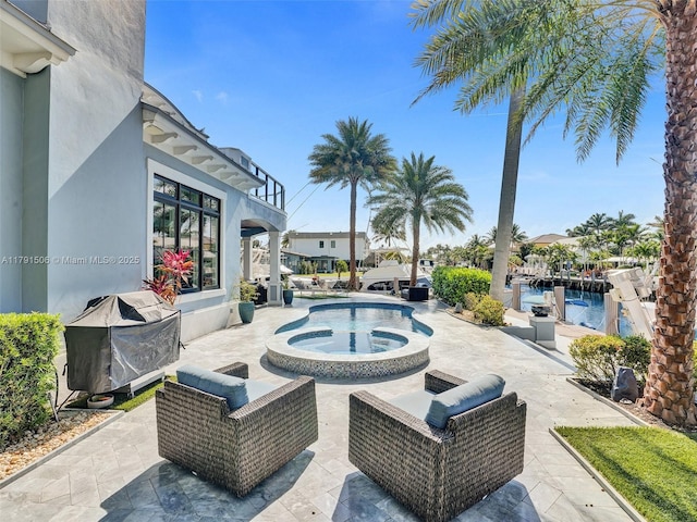 outdoor pool with grilling area, an in ground hot tub, and a patio area