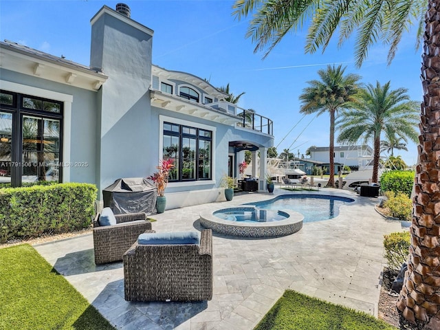 view of pool with a patio area and a pool with connected hot tub