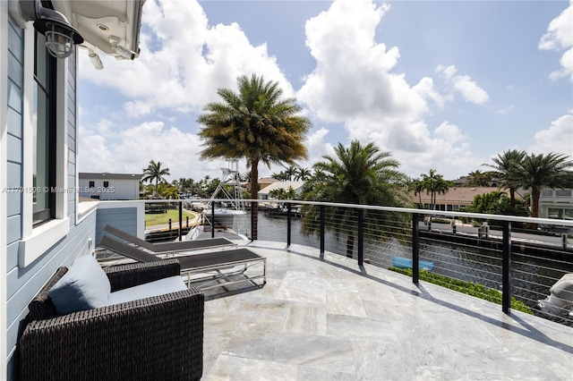 view of patio / terrace featuring a water view and a balcony