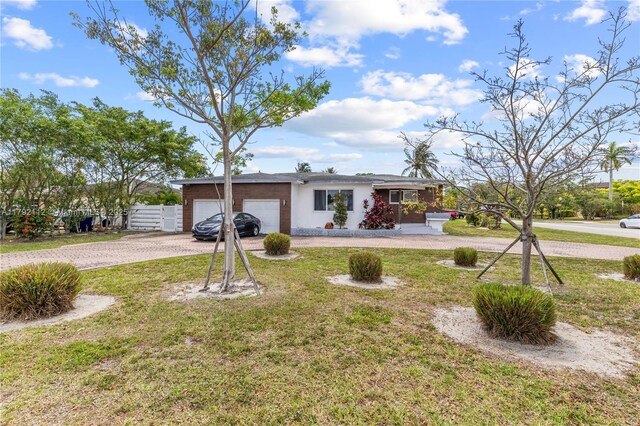 6690 Miramar Pkwy, Miramar, FL 33023 - ranch-style home with driveway, an attached garage, a front yard, and stucco siding