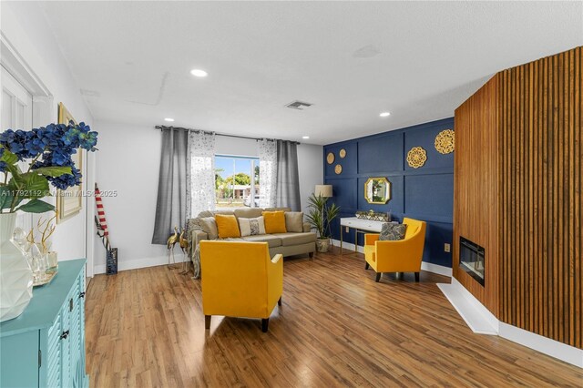 6690 Miramar Pkwy, Miramar, FL 33023 - living room featuring wood finished floors, recessed lighting, and a glass covered fireplace