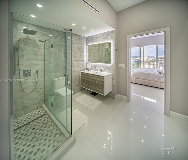 ensuite bathroom with tile patterned flooring, vanity, a marble finish shower, recessed lighting, and ensuite bathroom