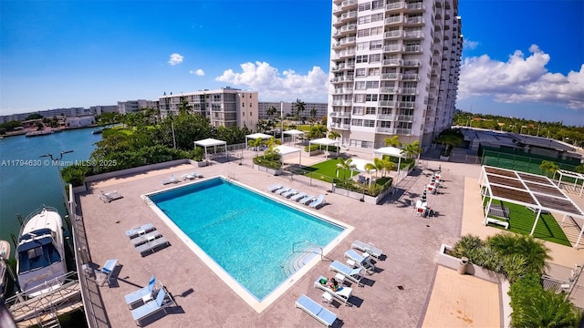 pool featuring a patio and a water view