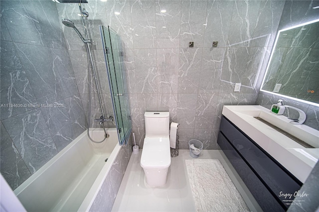 bathroom with vanity, shower / tub combination, toilet, and tile walls