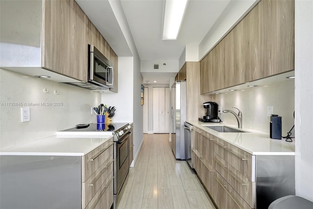 kitchen featuring stainless steel appliances, a sink, and modern cabinets