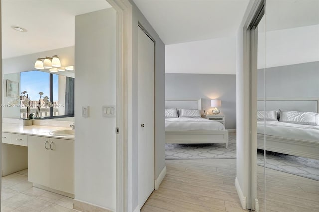 hallway featuring a sink and light wood-style floors