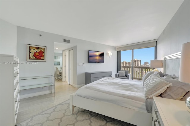 bedroom with baseboards, visible vents, access to exterior, and light wood finished floors