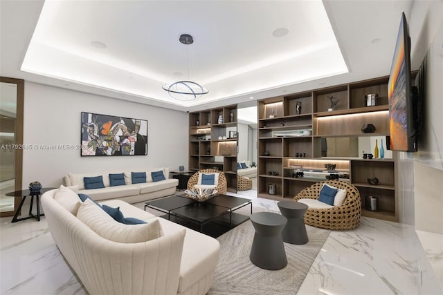 living room featuring marble finish floor and a raised ceiling