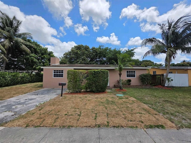 single story home with fence, stucco siding, and a front lawn
