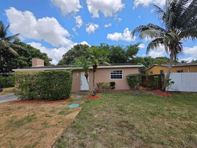 single story home with fence, stucco siding, a chimney, and a front lawn