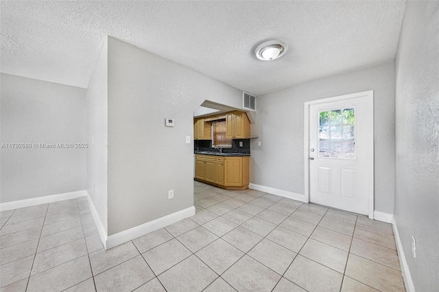 2821 N 74th Ave, Hollywood, FL 33024 - kitchen with dark countertops, light tile patterned floors, a textured ceiling, a sink, and tasteful backsplash
